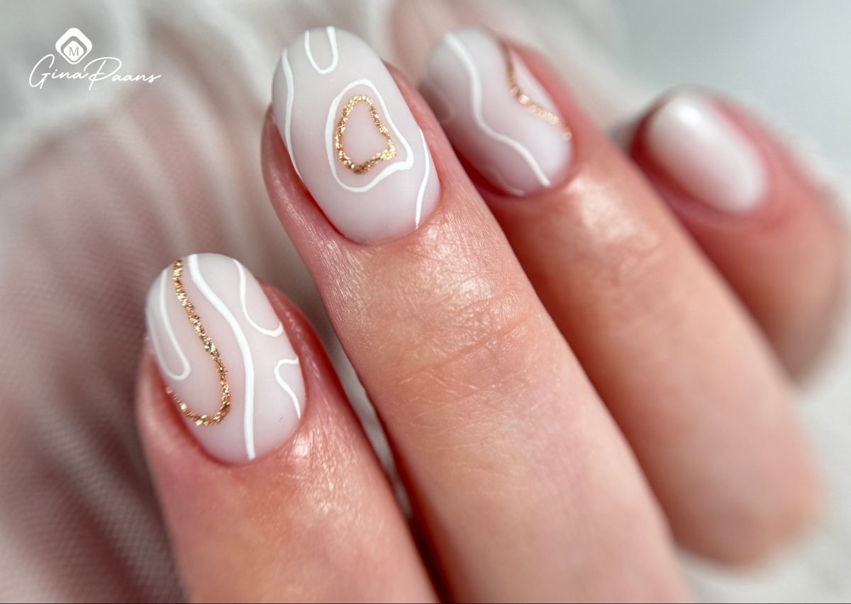 Nude nagels met witte en gouden lijntjes als nail art