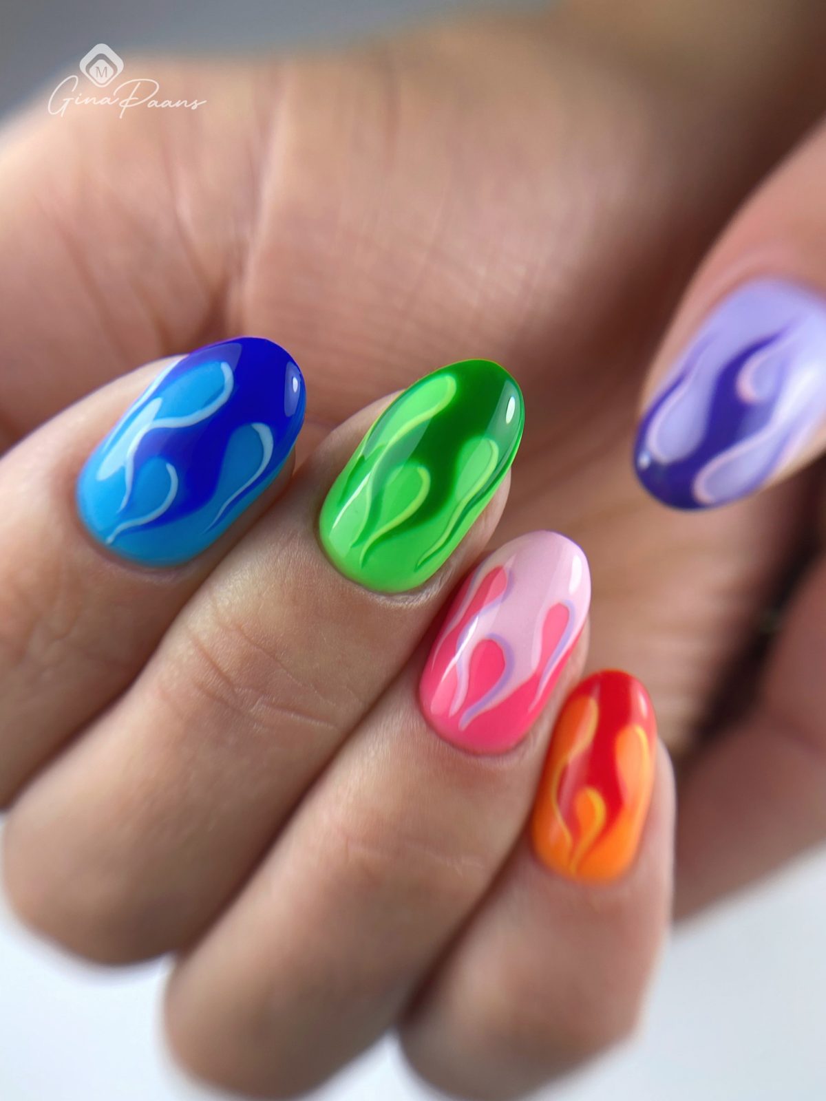 Nagels met kleurrijke vlammen in blauw, groen, paars, roze en oranje